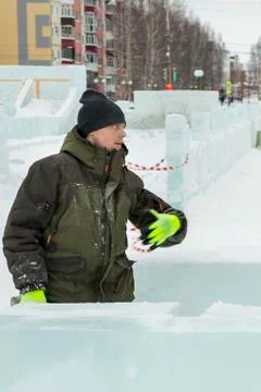 Assembler in overalls on the territory of the ice town Fotos Stock