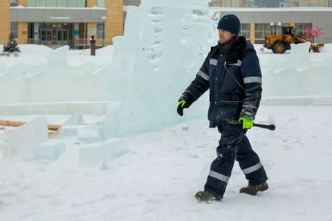 Assembler in overalls on the territory of the ice town Fotos Stock