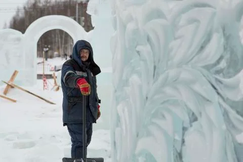 Assembler in overalls on the territory of the ice town 스톡 사진