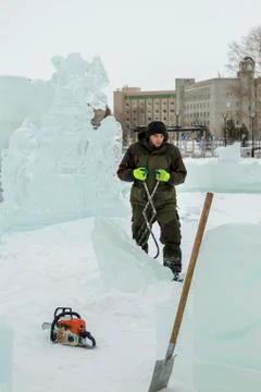 Assembler in overalls on the territory of the ice town 스톡 사진