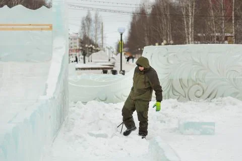 Assembler with steel tongs pulls ice block 写真素材