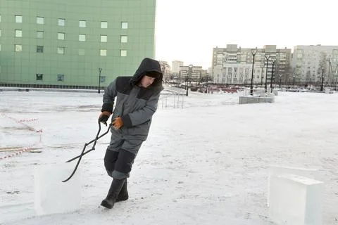 Assembler with steel tongs pulls ice block Stock-Fotos