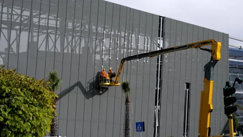 Assemblers are performing high-altitude installation work on the telescopic boom Stock Footage 148920115