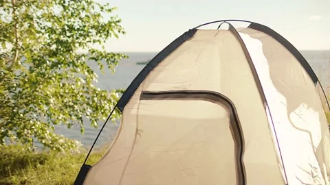 Assembling and setting up a tourist tent by the sea, river or lake during sunset Video stock 148189463