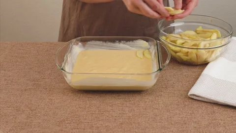 Assembling apple cake. Fresh peeled apple slices on top of dough Video stock 229907396