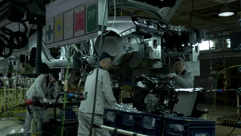 Assembling the car at the factory connecting the engine Stock Footage 142031191
