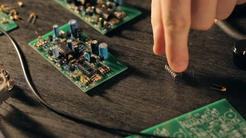 Assembling a circuit board. Putting microchip on PCB with fingers Video stock 97603776