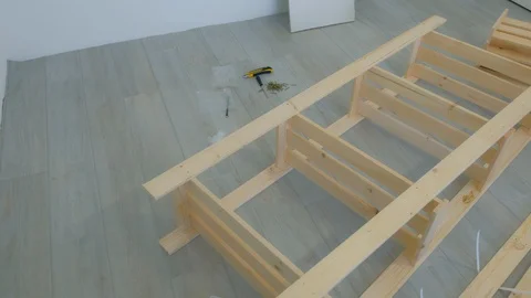 Assembling collecting wooden rack on the floor at home house, eco furniture. Stock Footage 129590224