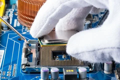 Assembling a computer in white gloves, installing a processor in its socket 写真素材
