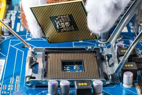 Assembling a computer in white gloves, installing a processor in its socket,  Stock Photos