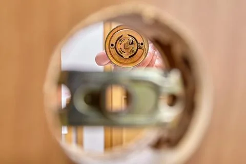 Assembling door lock with knob and latch, inserting bolt into assembly mechanism Fotos de archivo