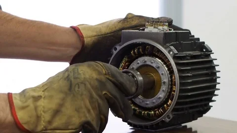 Assembling an electric induction motor by  inserting the rotor on the stator Stock Footage 82887357