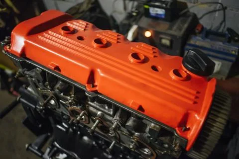 Assembling engine with red valve cap in dark garage Stock Photos