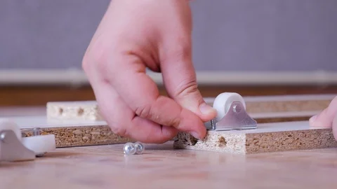 Assembling the furniture, fixing the wheels. Close up. Stock Footage 108610399