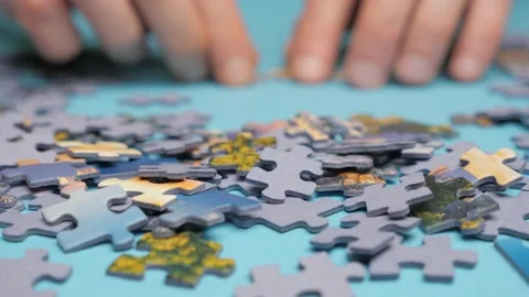 Assembling jigsaw puzzle. Hand matching jigsaw halves. Leisure activity Stock Footage 132466036