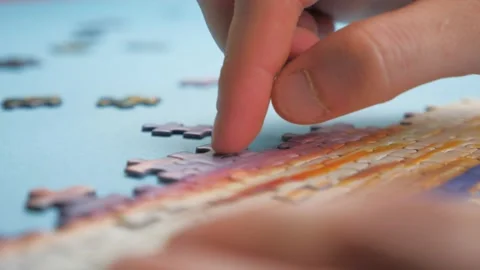Assembling jigsaw puzzle. Pieces of a jigsaw puzzle for entertainment when you Stock-Footage 132993950