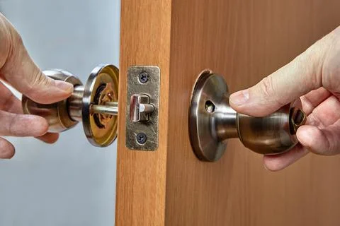 Assembling lock with door knobs and latch in living room. Foto stock