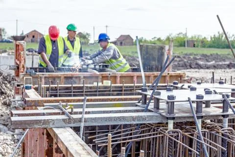 Assembling metal skeleton, welder is welding tied reinforcing rod and anchor Stock Photos