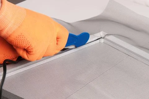 Assembling  mosquito net for  window, installing  seal in an aluminum profile Foto stock