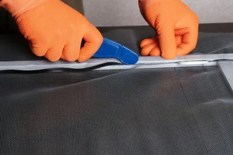 Assembling  mosquito net for  window, installing  seal in an aluminum profile Foto stock