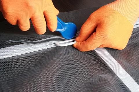 Assembling  mosquito net for  window, installing  seal in an aluminum profile Fotos de archivo