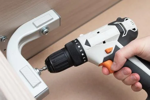 Assembling a new bed using a screwdriver Stock Photos