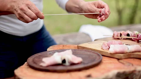 Assembling pork, prosciutto and prune kebabs Stock Footage 63305722