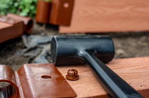 Assembling a raised bed garden panel with plastic connectors using a rubber Stock Photos