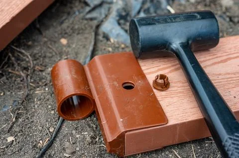 Assembling a raised bed garden panel with plastic connectors using a rubber Stock Photos
