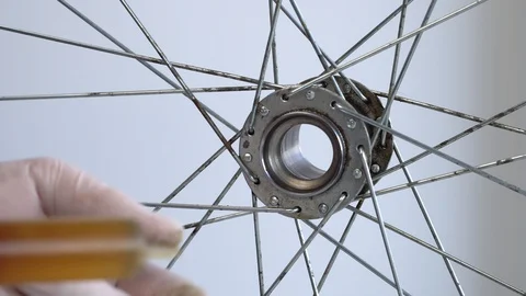 Assembling the rear hub of the bicycle wheel. Close-up shot A male hand in a Stock Footage 117533077