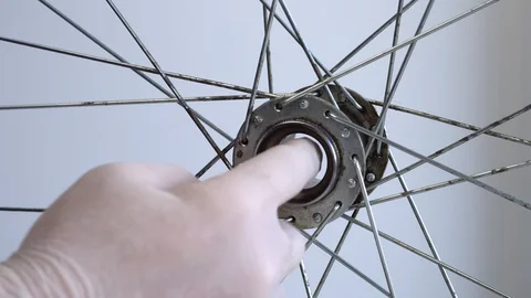 Assembling the rear hub of the bicycle wheel. Close-up shot A male hand in a Stock Footage 117533288