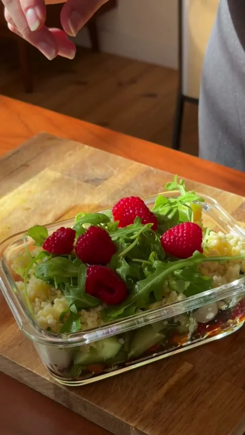 Assembling a salad with arugula raspberries and walnut pieces Stock Footage 331778583