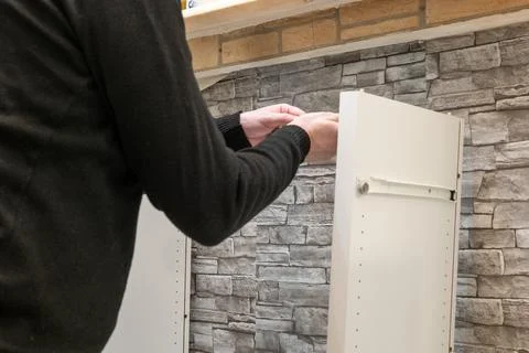 Assembling a white flatpack closet Stock Photos