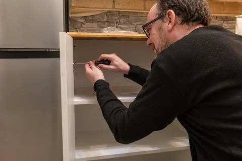 Assembling a white flatpack closet Stock Photos