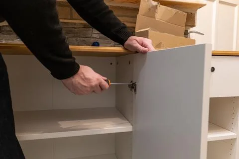 Assembling a white flatpack closet Stock Photos