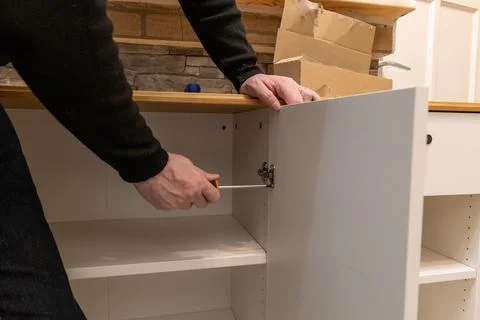 Assembling a white flatpack closet Stock Photos