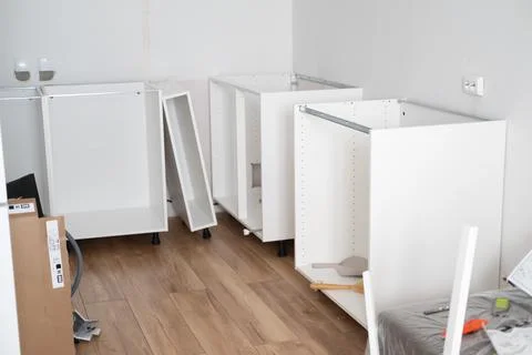 Assembling the white frames of the modular kitchen. Step by step assembly Stock Photos