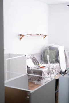Assembling the white frames of the modular kitchen. Step by step assembly Stock Photos