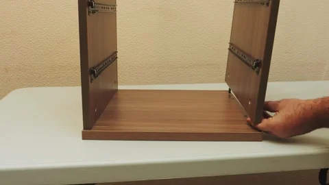 Assembling wooden interior furniture using a screwdriver. Medium shot. Stock Footage 339093583