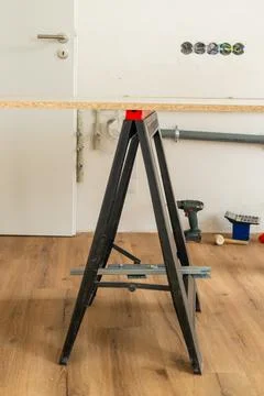 Assembling work surface at DIY project station using sturdy black sawhorse Foto stock