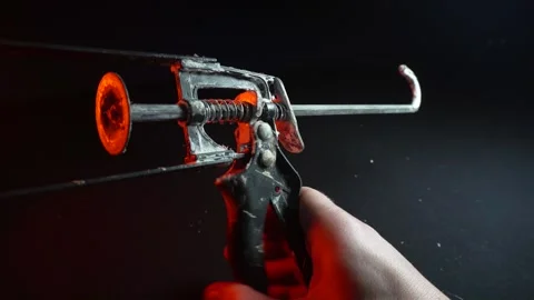 Assembly gun for sealants for construction work in red light Stockbeeldmateriaal 302340459
