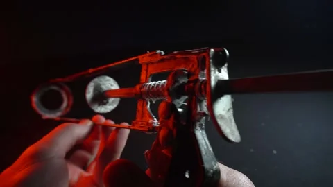 Assembly gun for sealants for construction work in red light Vídeos de archivo 302340484