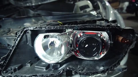Assembly of the headlight after repair and replacement of bulbs Stock Footage 303957768