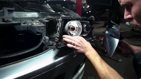 Assembly of the headlight after repair and replacement of bulbs Stock Footage 303957780