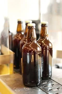 Assembly line, beer and bottles in factory, brewery or manufacturing plant Stock Photos