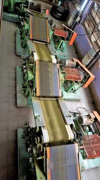 Assembly line of processing of tea leaves by machines from raw material leave Stock Photos