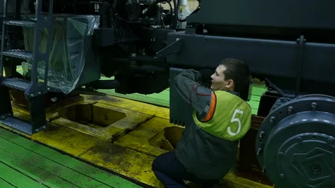Assembly line workers on tractor factory.  Workmen working on a factory. Stockbeeldmateriaal 110735566