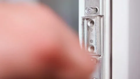 Assembly of plastic doors close-up. Screwing metal parts to the plastic door Stock Footage 230557084