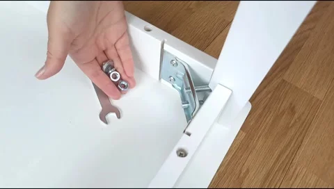 Assembly of table frame by attaching table leg with metal brackets,bolts and nut Stock Footage 339178213