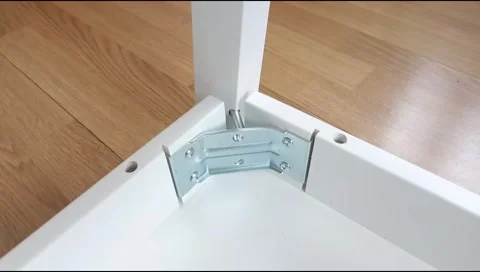 Assembly of table frame by attaching table leg with metal brackets,bolts and nut Stock Footage 339178360